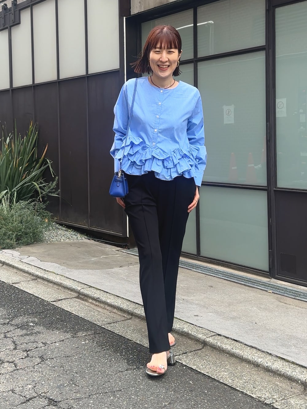 ブルー系のシャツ/ブラウス、ブラック系のその他パンツ、ベージュ系のショルダーバッグを着用したレディースの春コーディネートの6枚目の写真