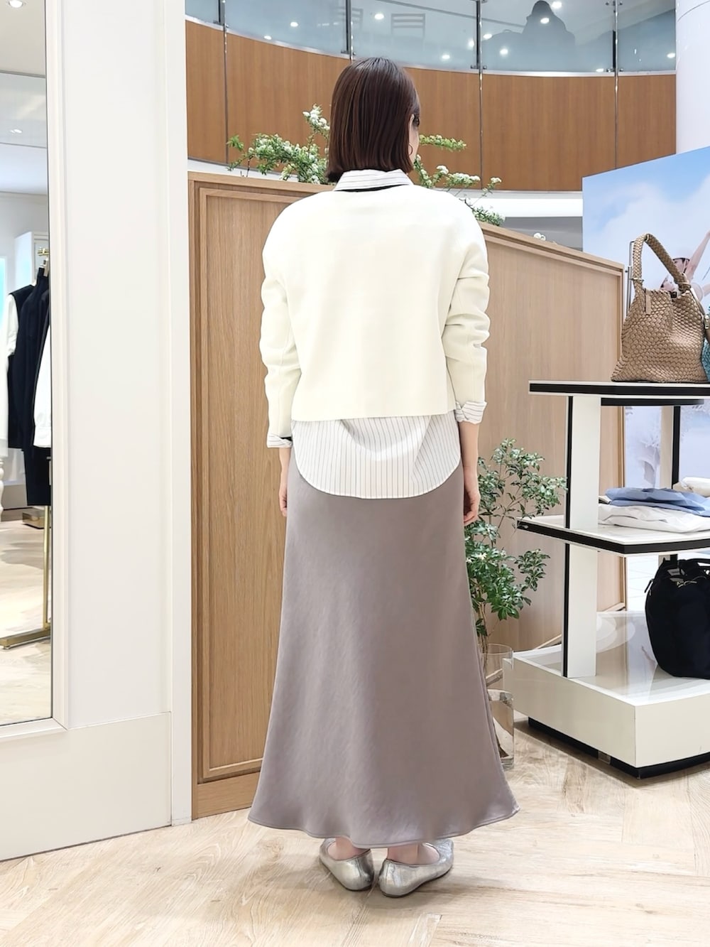 ベージュ系のトートバッグ、ホワイト系のシャツ/ブラウス、グリーン系のスカートを着用したレディースの春コーディネートの4枚目の写真