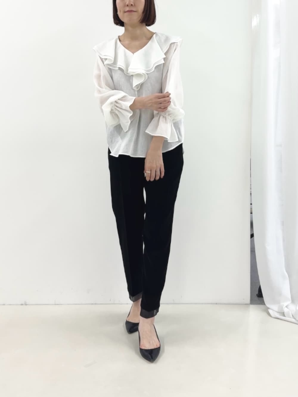 ブラック系のその他パンツ、ホワイト系のシャツ/ブラウスを着用したレディースの冬コーディネートの2枚目の写真