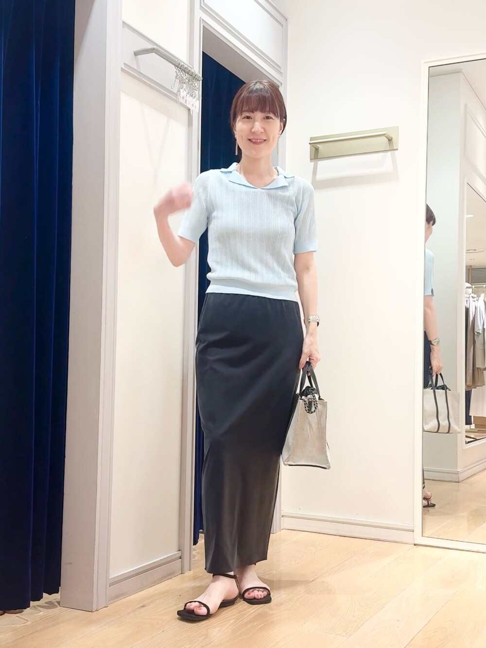 ブラック系のスカート、ベージュ系のタンクトップ、ブルー系のニット/セーターを着用したレディースの夏コーディネートの4枚目の写真