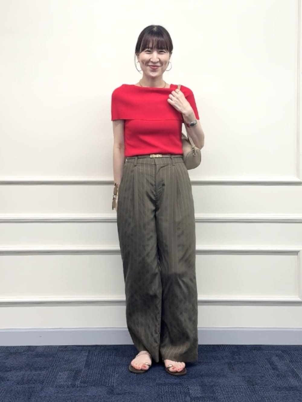 レッド系のニット/セーター、グリーン系のその他パンツ、ベージュ系のショルダーバッグを着用したレディースの夏コーディネートの3枚目の写真