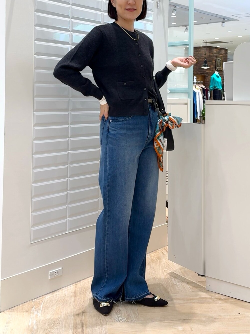 ブルー系のデニムパンツ、グレー系のカーディガン/ボレロ、ホワイト系のTシャツ/カットソーを着用したレディースの秋コーディネートの4枚目の写真