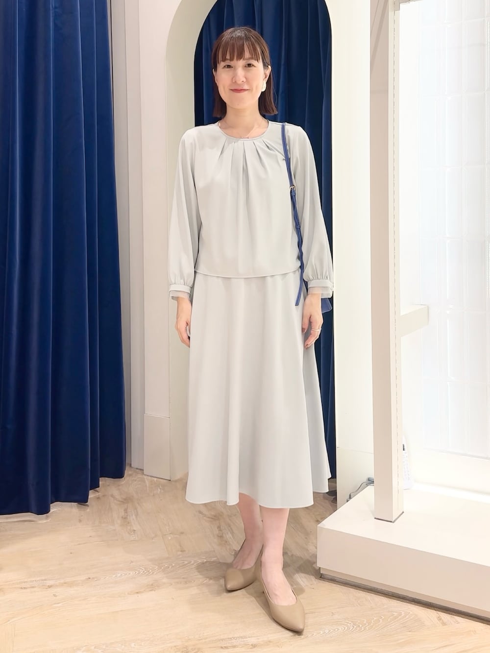 ブルー系のスカート、ブルー系のシャツ/ブラウス、ホワイト系のショルダーバッグを着用したレディースの秋コーディネートの3枚目の写真