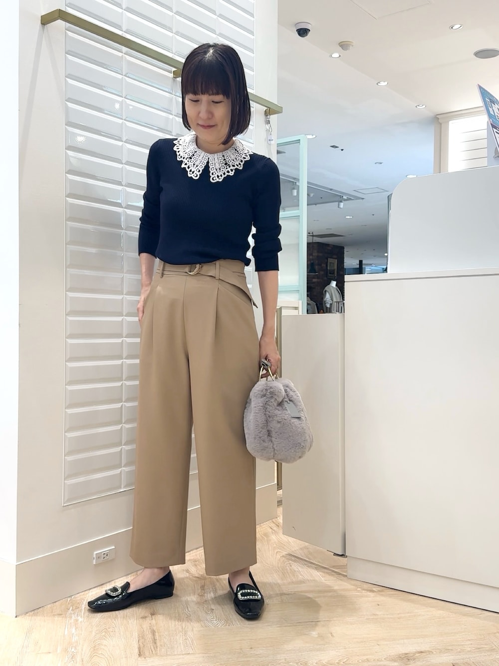 ベージュ系のその他パンツ、グレー系のショルダーバッグ、ブルー系のニット/セーターを着用したレディースの秋コーディネートの5枚目の写真