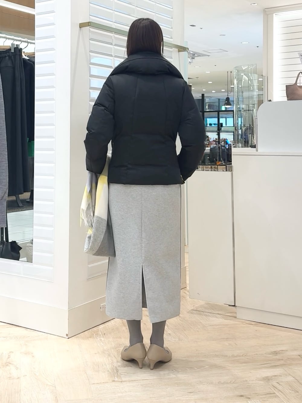 ブラック系のダウンジャケット/コート、パープル系のカーディガン/ボレロ、グレー系のスカートを着用したレディースの秋コーディネートの5枚目の写真