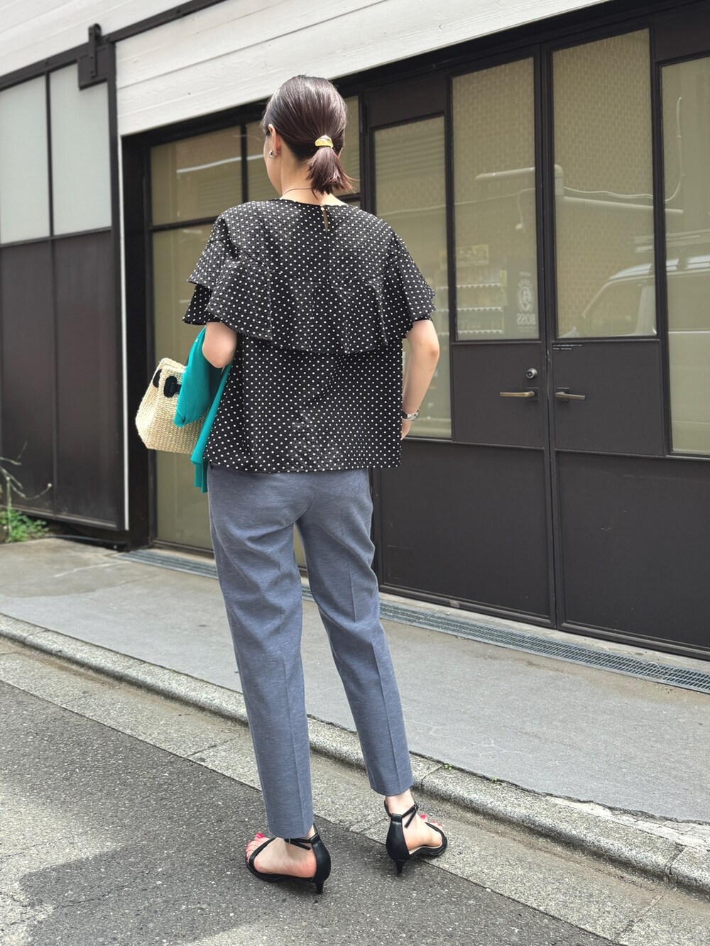 ゴールド系のサンダル、ブルー系のその他パンツ、ブラック系のかごバッグを着用したレディースの春コーディネートの4枚目の写真