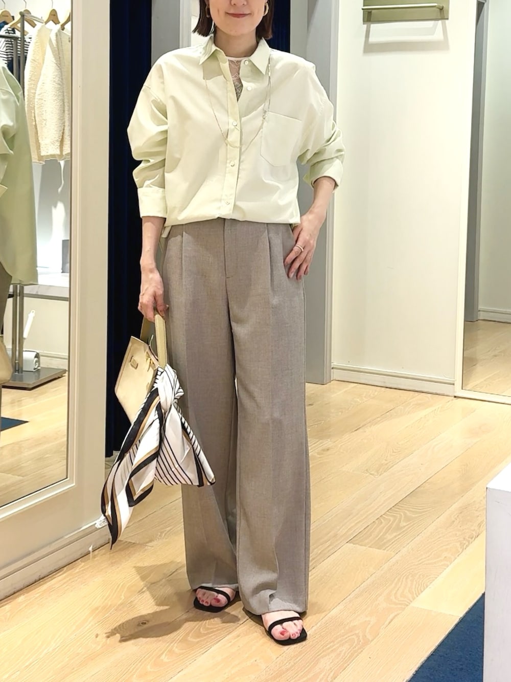 ベージュ系のその他パンツ、ベージュ系のトートバッグ、ホワイト系のシャツ/ブラウスを着用したレディースの春コーディネートの9枚目の写真