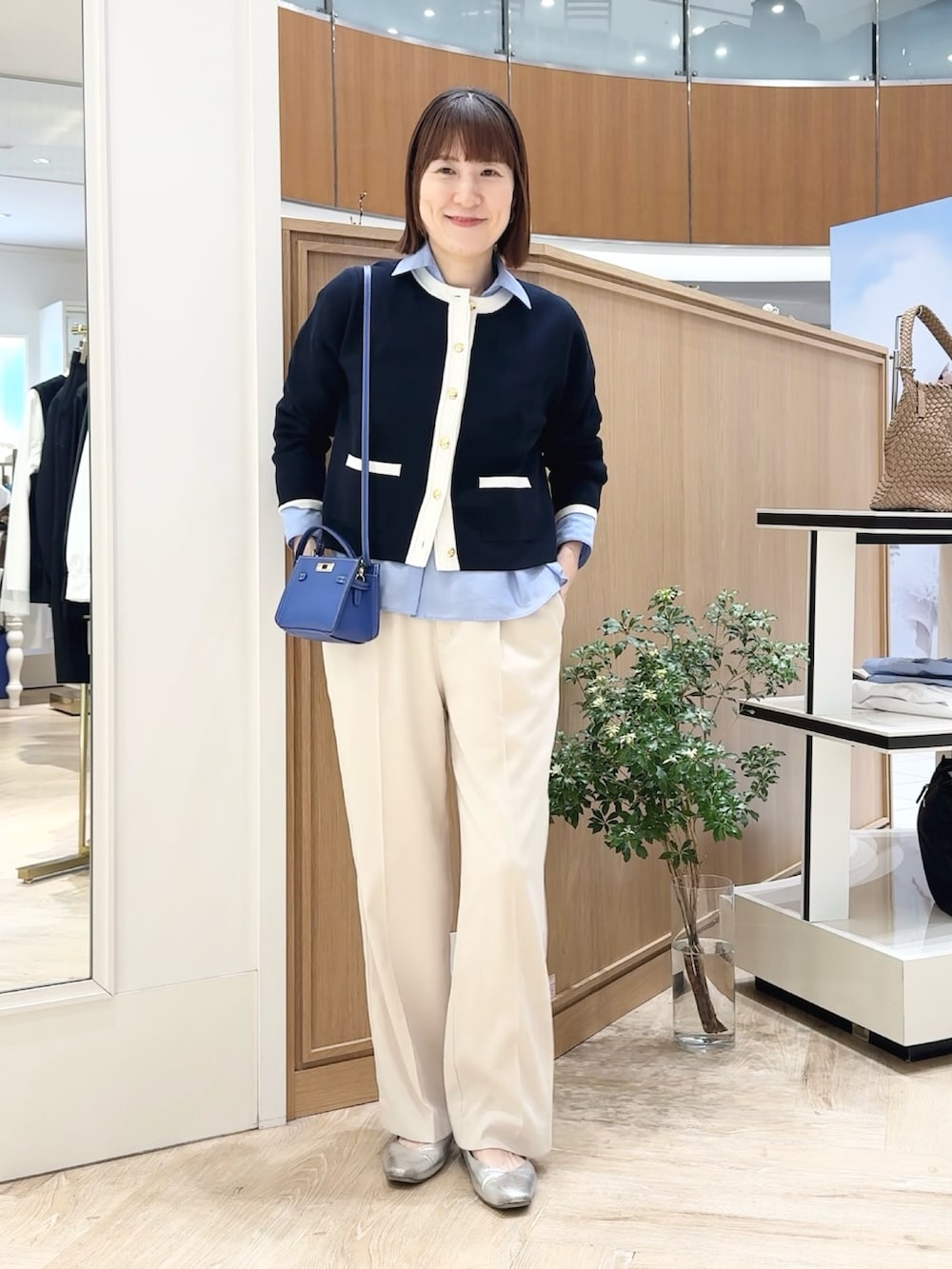 ブルー系のカーディガン/ボレロ、ホワイト系のその他パンツ、ブルー系のショルダーバッグを着用したレディースの春コーディネートの4枚目の写真