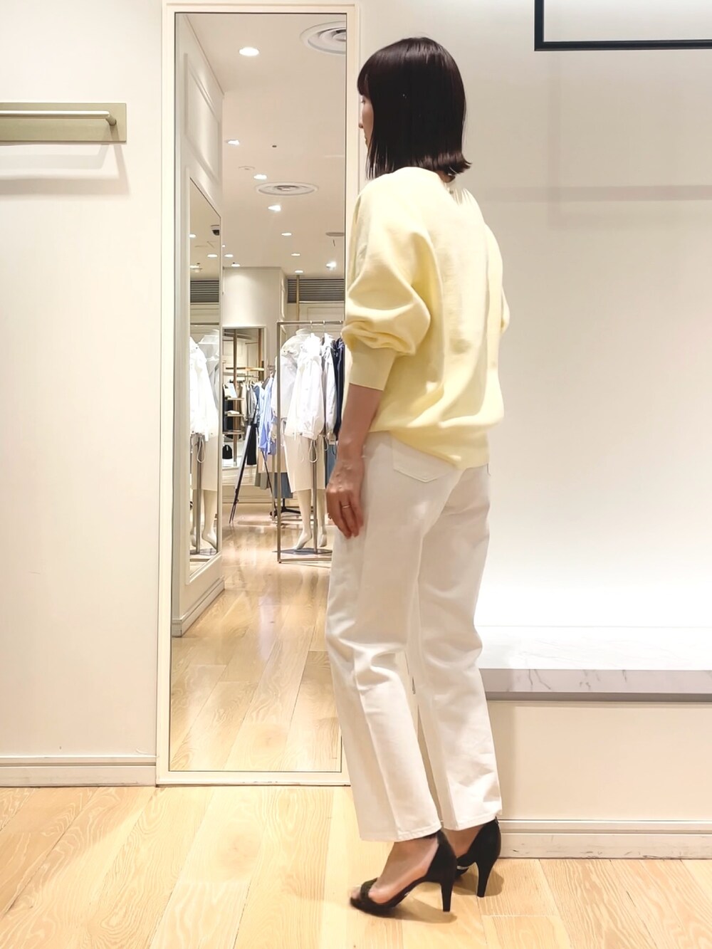 ベージュ系のニット/セーター、イエロー系のニット/セーターを着用したレディースの春コーディネートの3枚目の写真