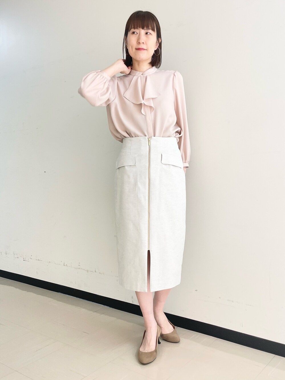 ベージュ系のスカート、ホワイト系のノーカラージャケット、ピンク系のシャツ/ブラウスを着用したレディースの春コーディネートの2枚目の写真