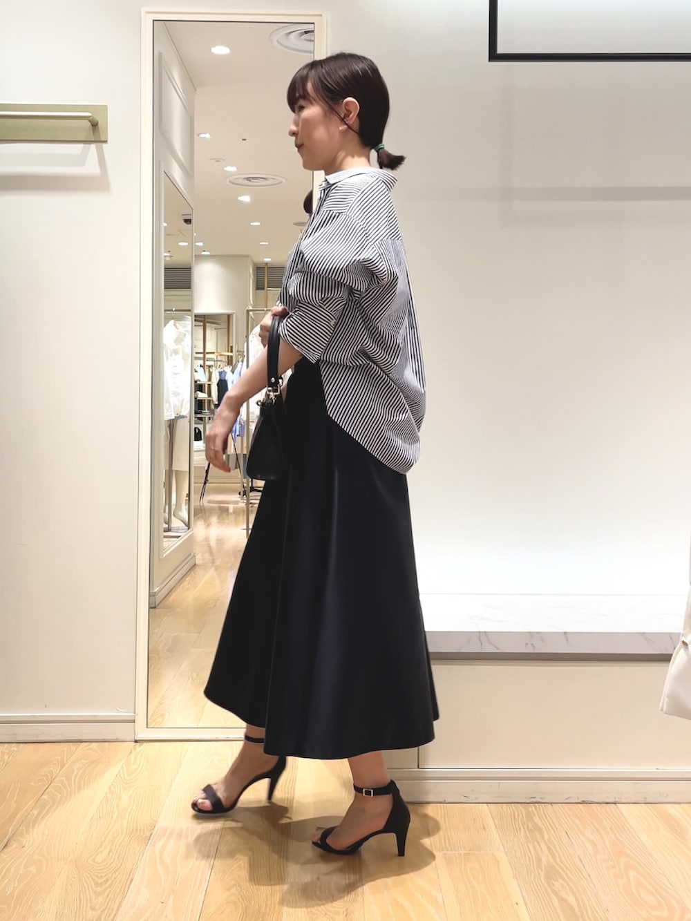 ホワイト系のシャツ/ブラウス、ブルー系のスカート、ブラック系のショルダーバッグを着用したレディースの春コーディネートの6枚目の写真