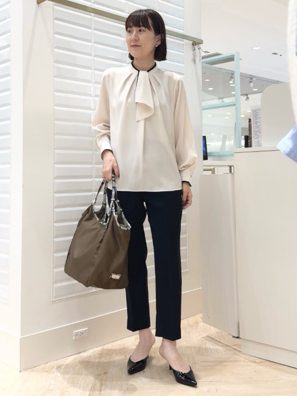 ブルー系のその他パンツ、ブラウン系のトートバッグ、ホワイト系のシャツ/ブラウスを着用したレディースの秋コーディネートの6枚目の写真