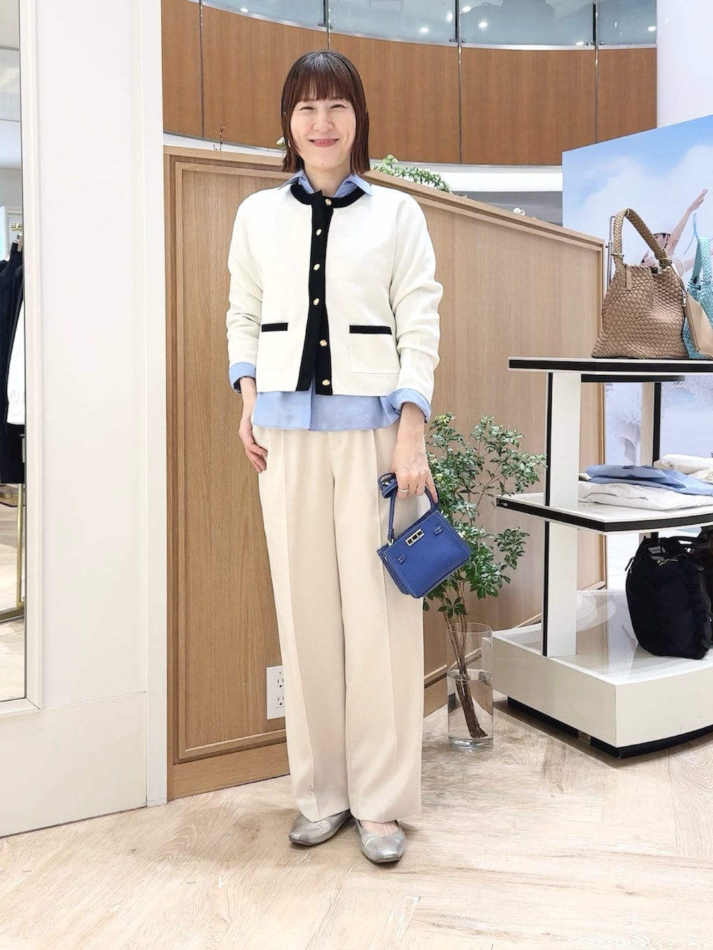 ブルー系のシャツ/ブラウス、ホワイト系のカーディガン/ボレロ、ブルー系のショルダーバッグを着用したレディースの春コーディネートの7枚目の写真