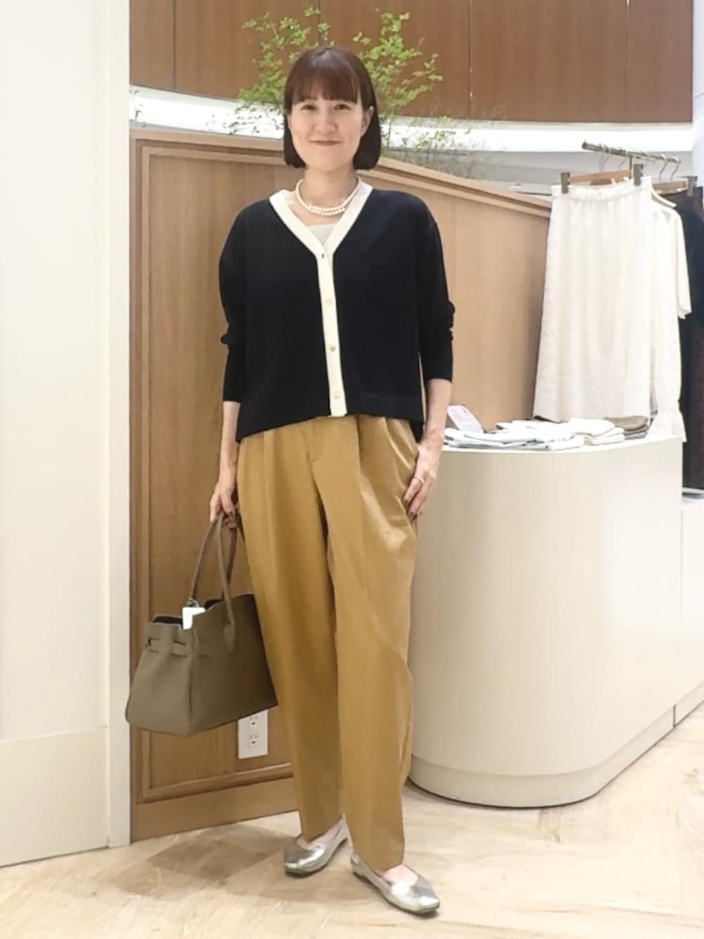 ブルー系のカーディガン/ボレロ、イエロー系のその他パンツ、ベージュ系のトートバッグを着用したレディースの秋コーディネートの2枚目の写真