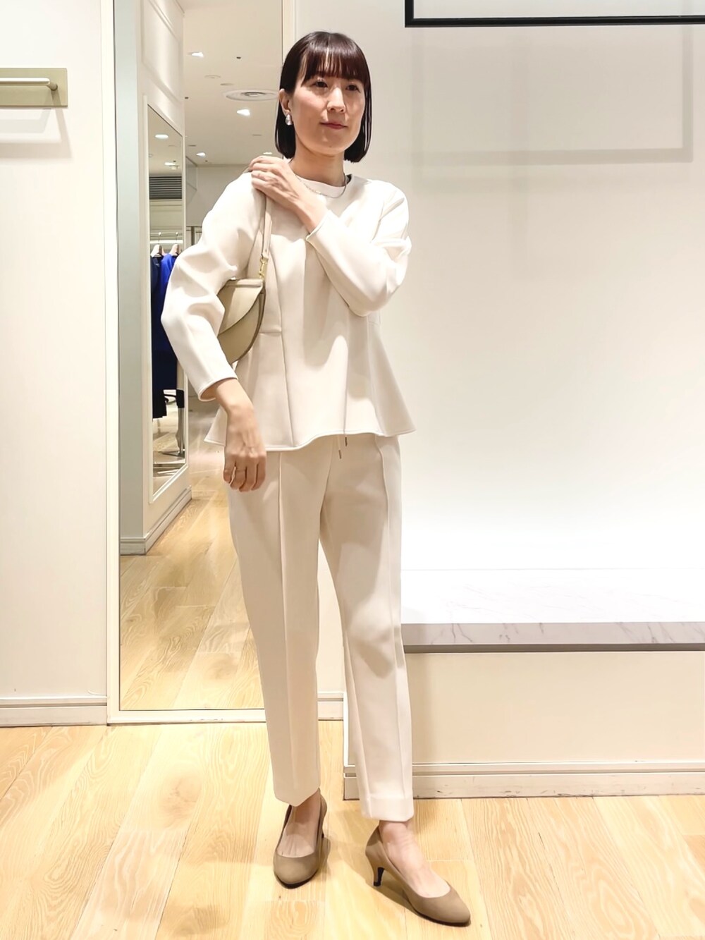 ホワイト系のその他パンツ、ホワイト系のTシャツ/カットソー、ブラック系のショルダーバッグを着用したレディースの冬コーディネートの3枚目の写真