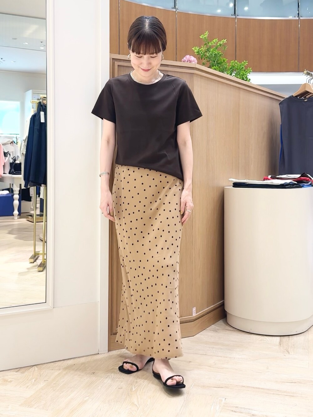 ブラウン系のスカート、ブラウン系のTシャツ/カットソー、シルバー系のチョーカーを着用したレディースの夏コーディネートの3枚目の写真