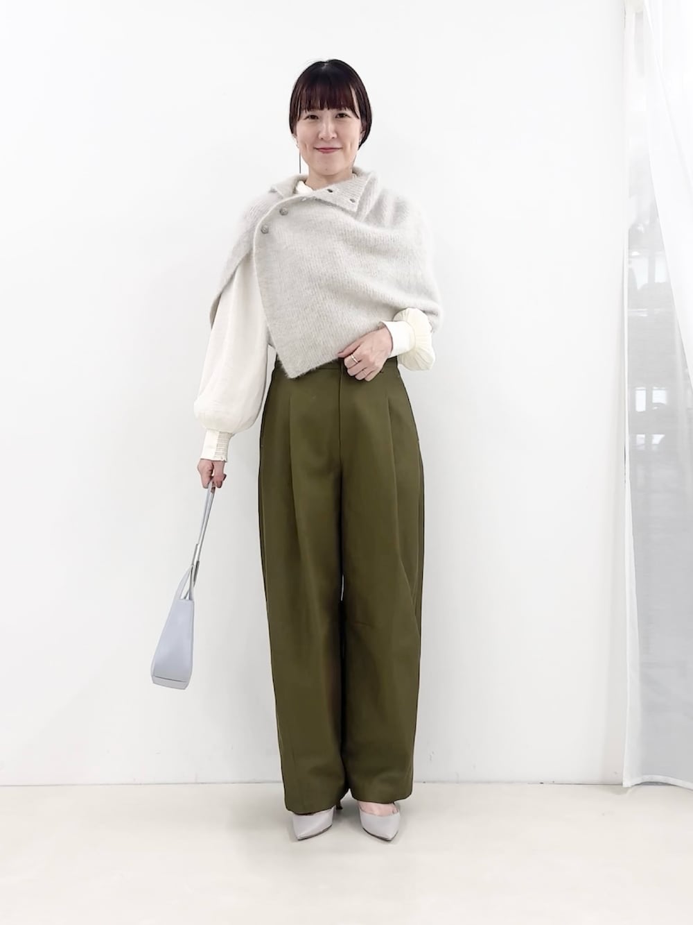 ブルー系のショルダーバッグ、グリーン系のチノパンツ、ホワイト系のシャツ/ブラウスを着用したレディースの秋コーディネートの6枚目の写真