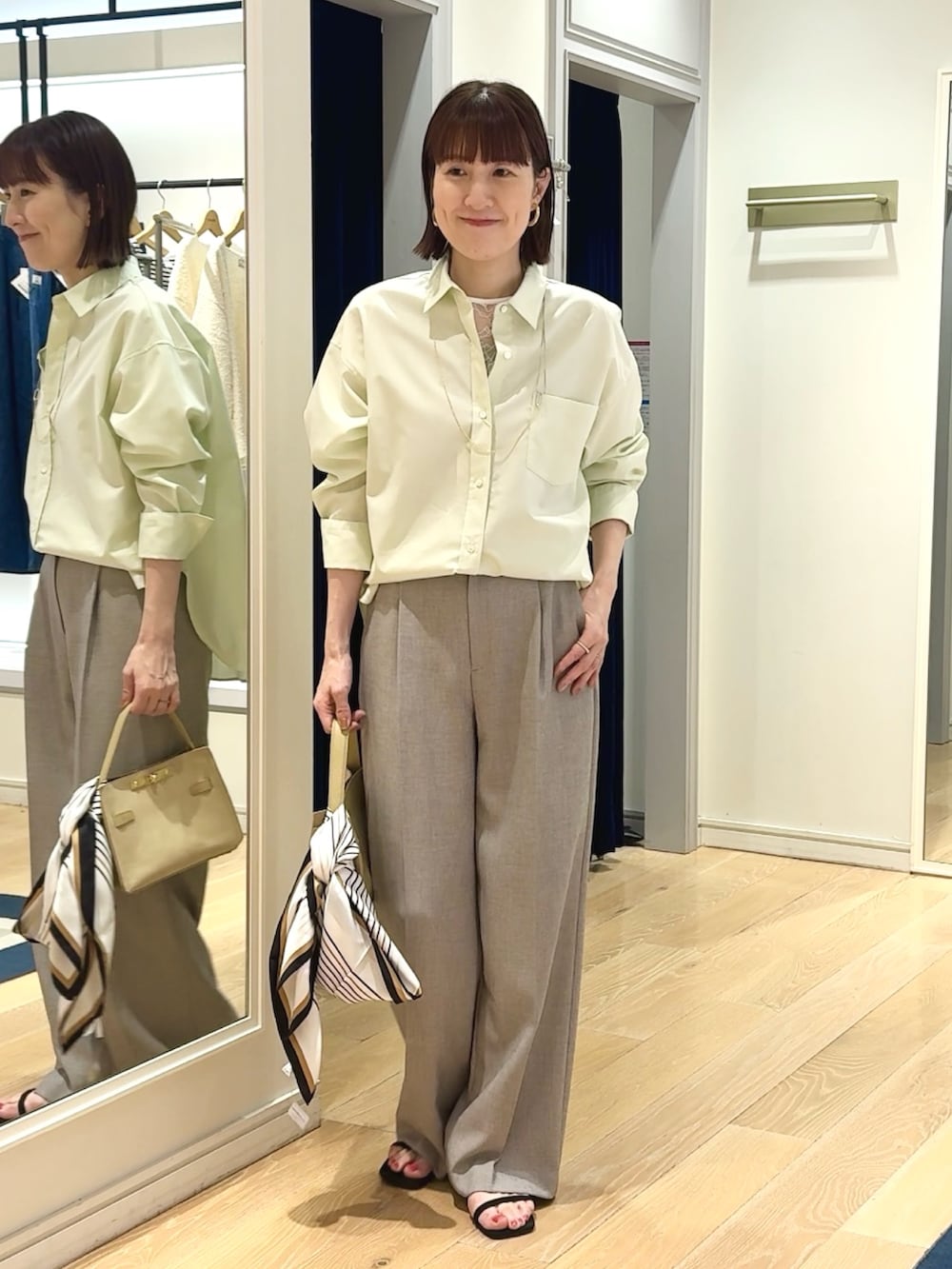 ベージュ系のその他パンツ、ベージュ系のトートバッグ、ホワイト系のシャツ/ブラウスを着用したレディースの春コーディネートの5枚目の写真