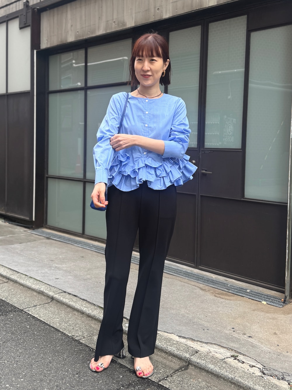 ブルー系のシャツ/ブラウス、ブラック系のその他パンツ、ベージュ系のショルダーバッグを着用したレディースの春コーディネートの3枚目の写真