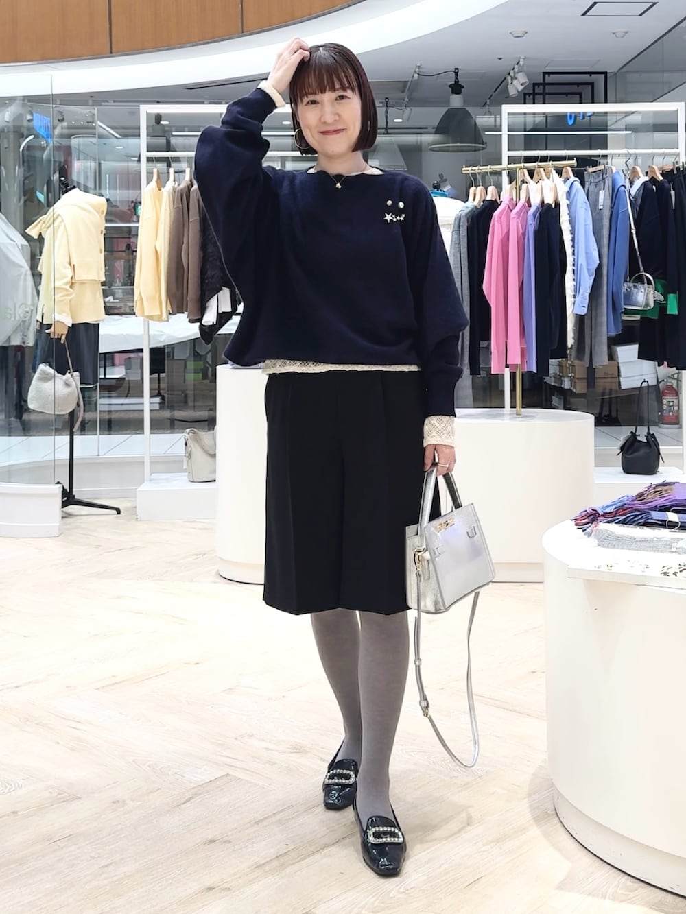 ブルー系のニット/セーター、ブラック系のその他パンツ、ホワイト系のカーディガン/ボレロを着用したレディースの冬コーディネートの5枚目の写真