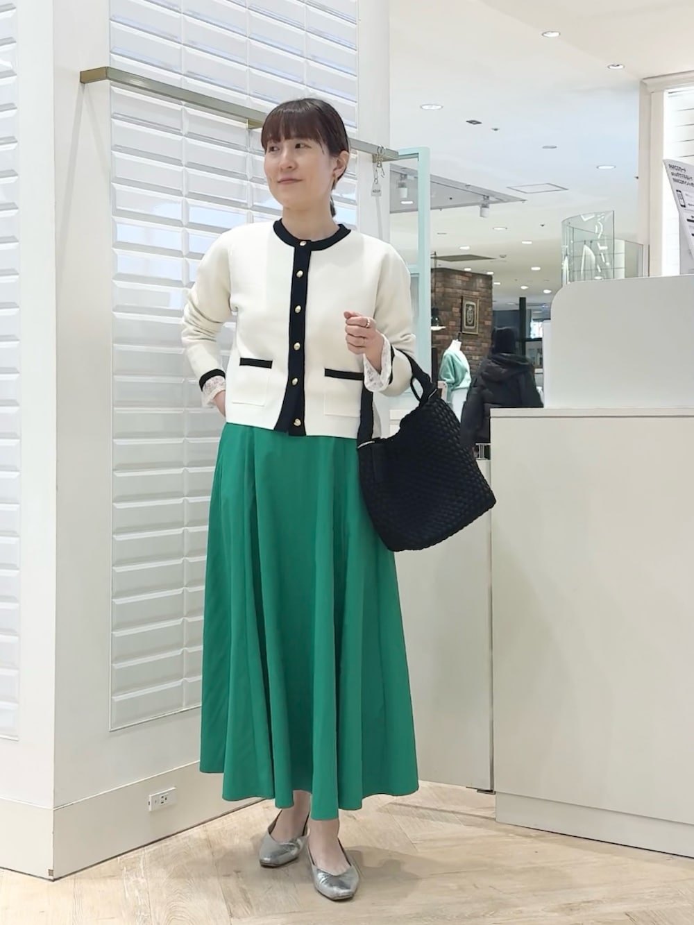 ホワイト系のカーディガン/ボレロ、グリーン系のスカート、ブラック系のショルダーバッグを着用したレディースの春コーディネートの5枚目の写真