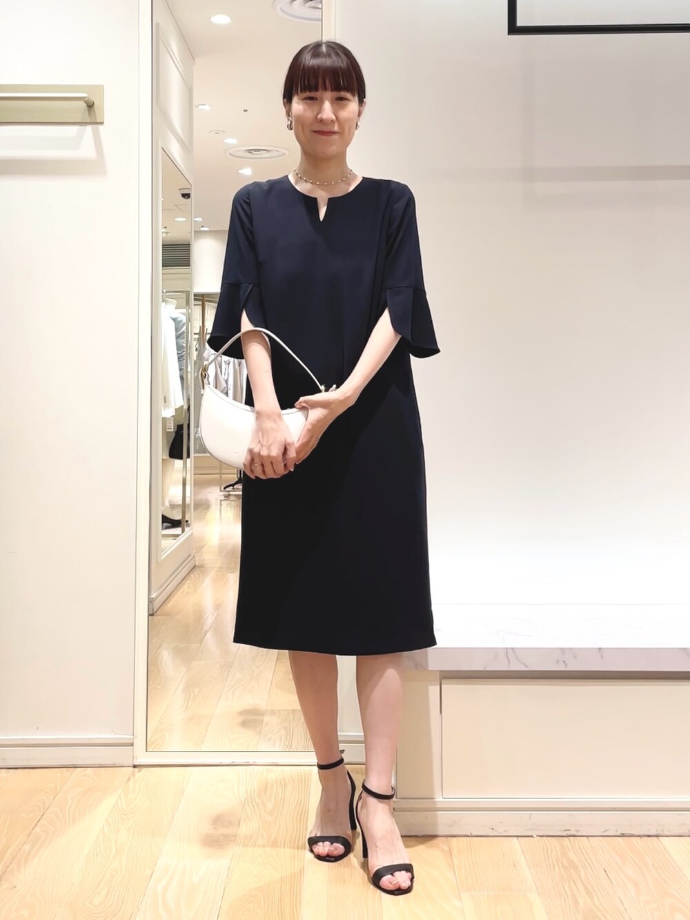 ブルー系のワンピース、ホワイト系のショルダーバッグ、シルバー系のイヤリングを着用したレディースの春コーディネートの7枚目の写真