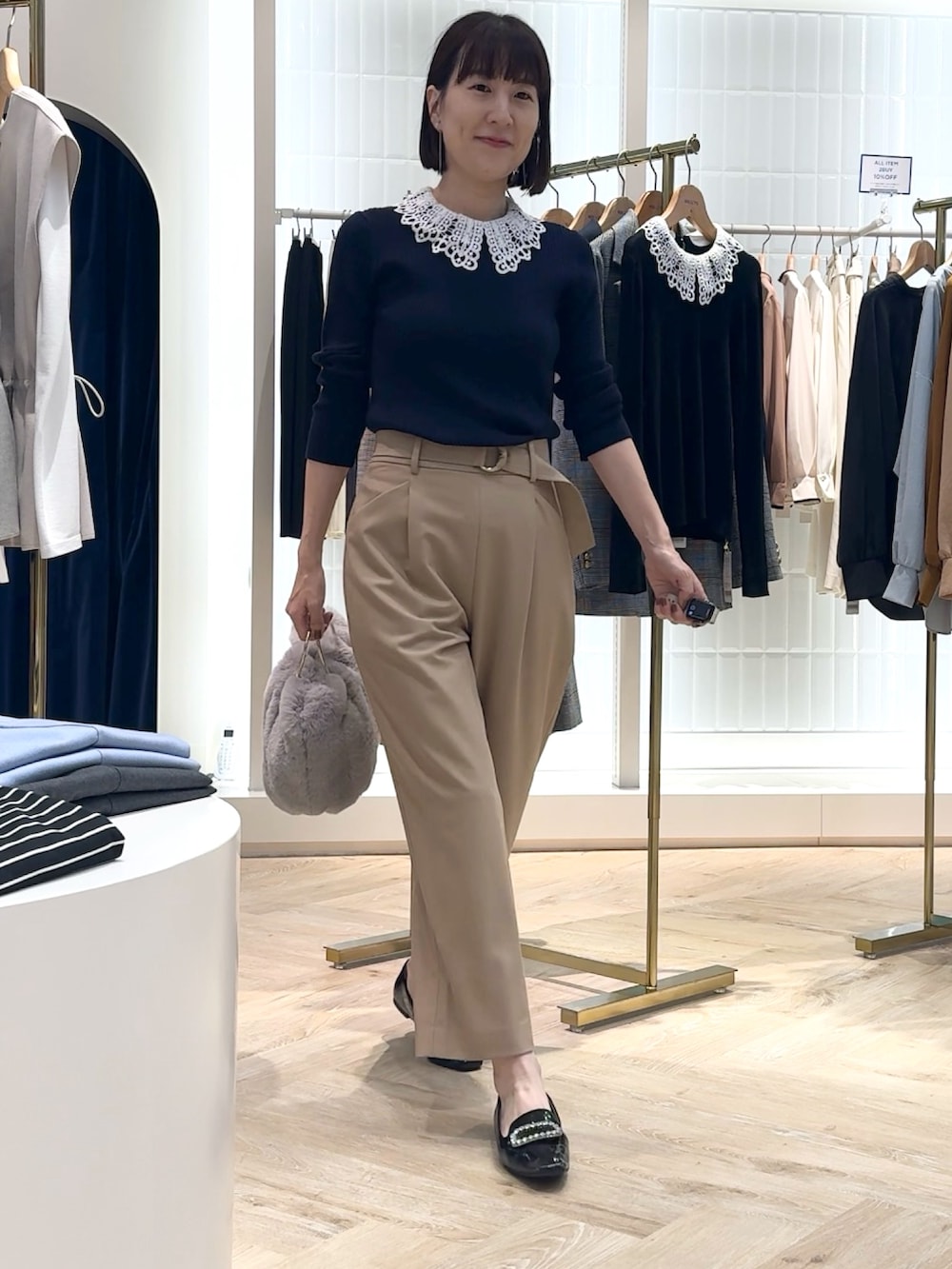 ベージュ系のその他パンツ、グレー系のショルダーバッグ、ブルー系のニット/セーターを着用したレディースの秋コーディネートの8枚目の写真