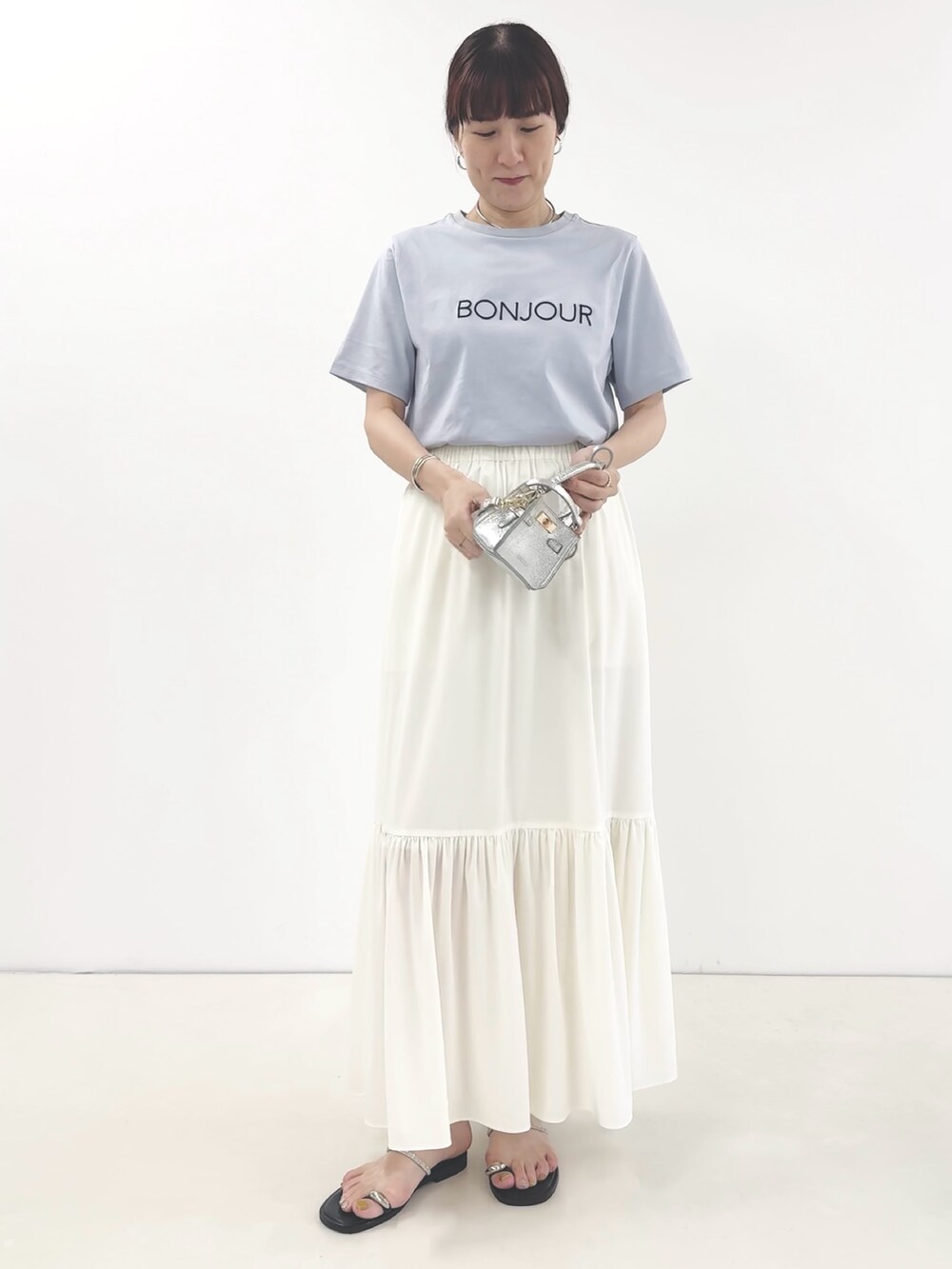 ホワイト系のスカート、シルバー系のサンダル、ブルー系のTシャツ/カットソーを着用したレディースの夏コーディネートの3枚目の写真