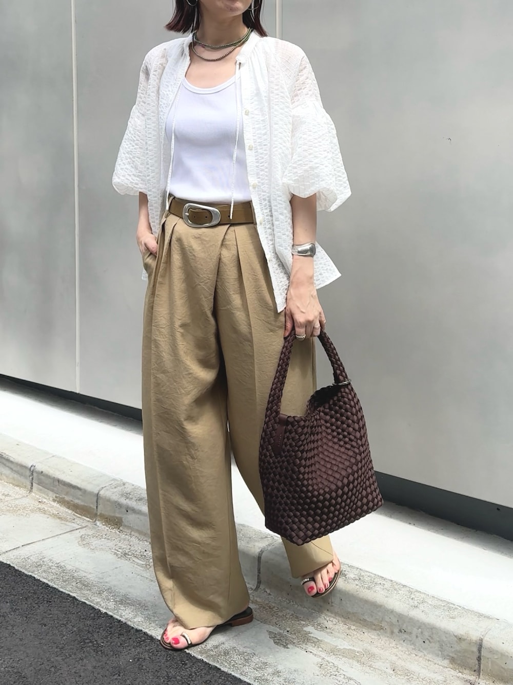 イエロー系のその他パンツ、ホワイト系のタンクトップ、ブラウン系のショルダーバッグを着用したレディースの夏コーディネートの4枚目の写真