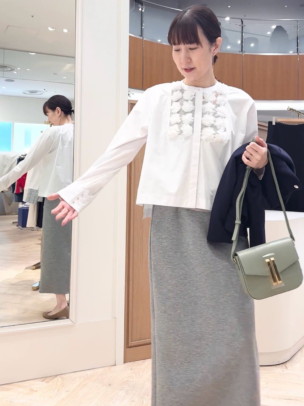 グレー系のスカート、ブルー系のブルゾン、ホワイト系のシャツ/ブラウスを着用したレディースの冬コーディネートの4枚目の写真