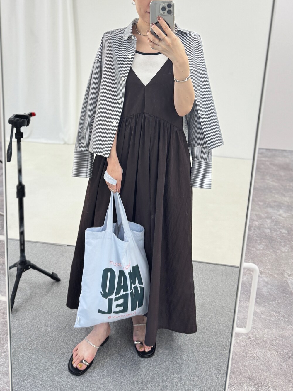 ブルー系のトートバッグ、シルバー系のサンダル、ブラウン系のワンピースを着用したレディースの夏コーディネートの5枚目の写真