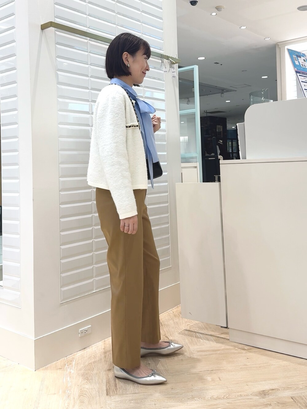 ブルー系のシャツ/ブラウス、ブラック系のボストンバッグ、イエロー系のその他パンツを着用したレディースの秋コーディネートの6枚目の写真