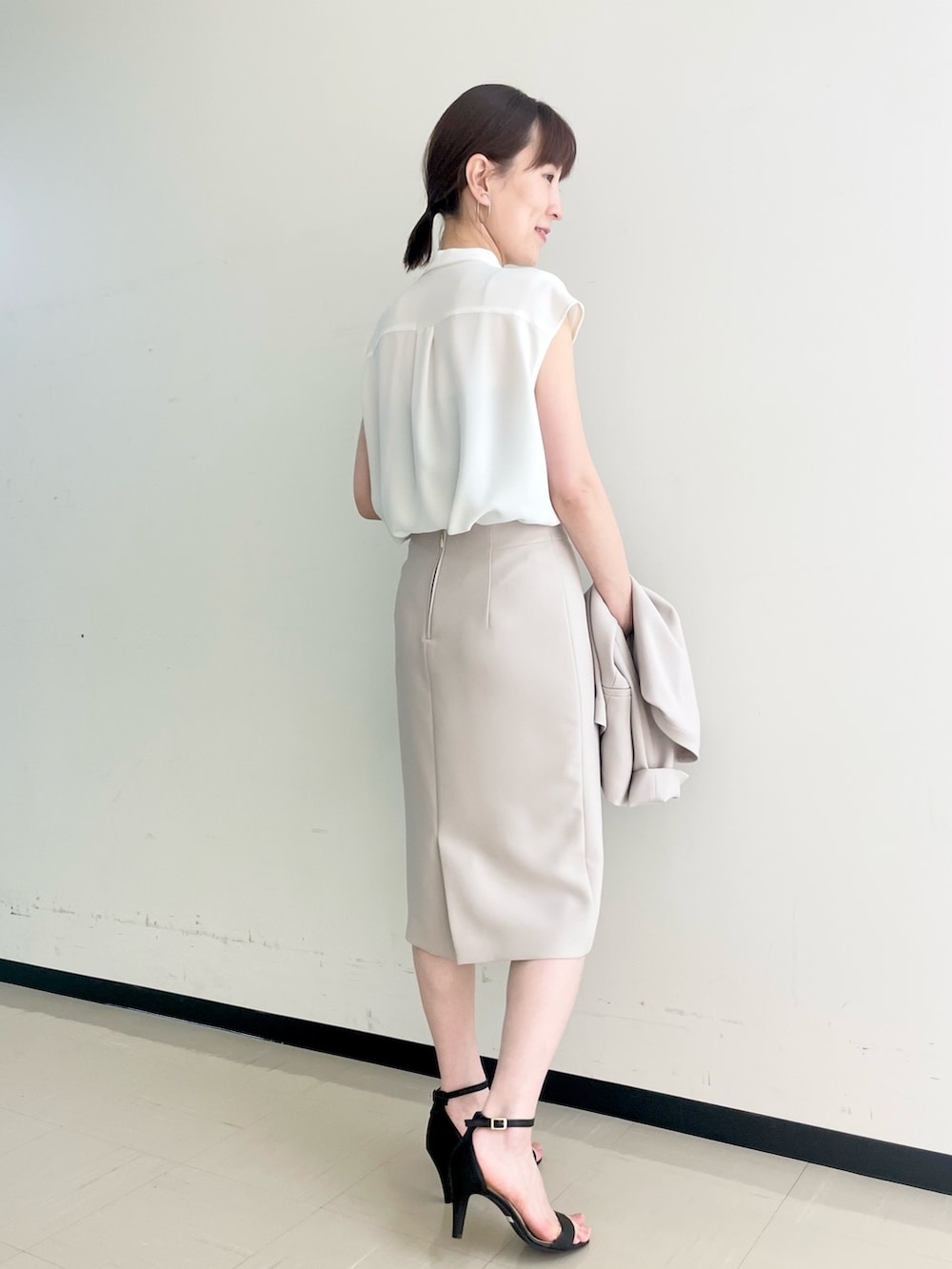 ベージュ系のスカート、ホワイト系のシャツ/ブラウス、ベージュ系のノーカラージャケットを着用したレディースの春コーディネートの6枚目の写真