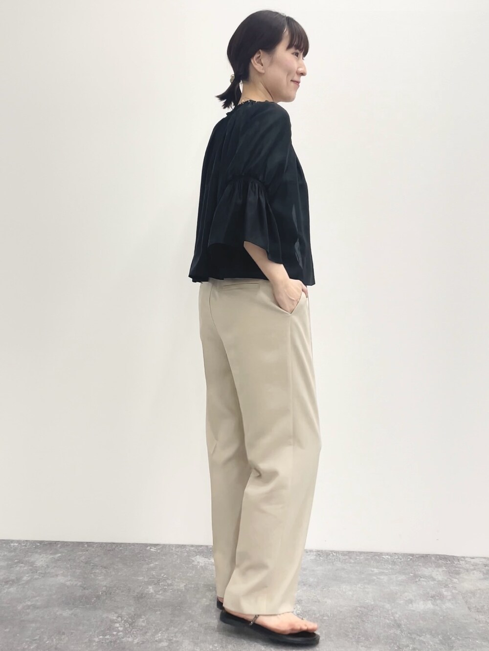 ベージュ系のその他パンツ、ベージュ系のニット/セーター、ブラック系のシャツ/ブラウスを着用したレディースの春コーディネートの3枚目の写真