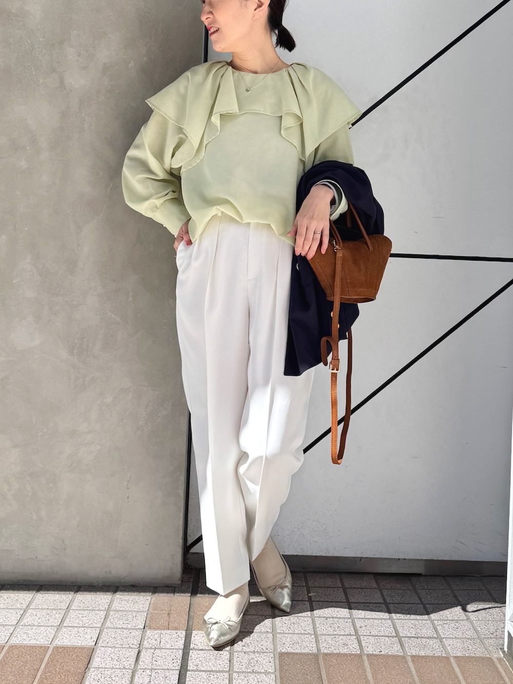 ホワイト系のその他パンツ、ブルー系のテーラードジャケット、イエロー系のトートバッグを着用したレディースの春コーディネートの5枚目の写真