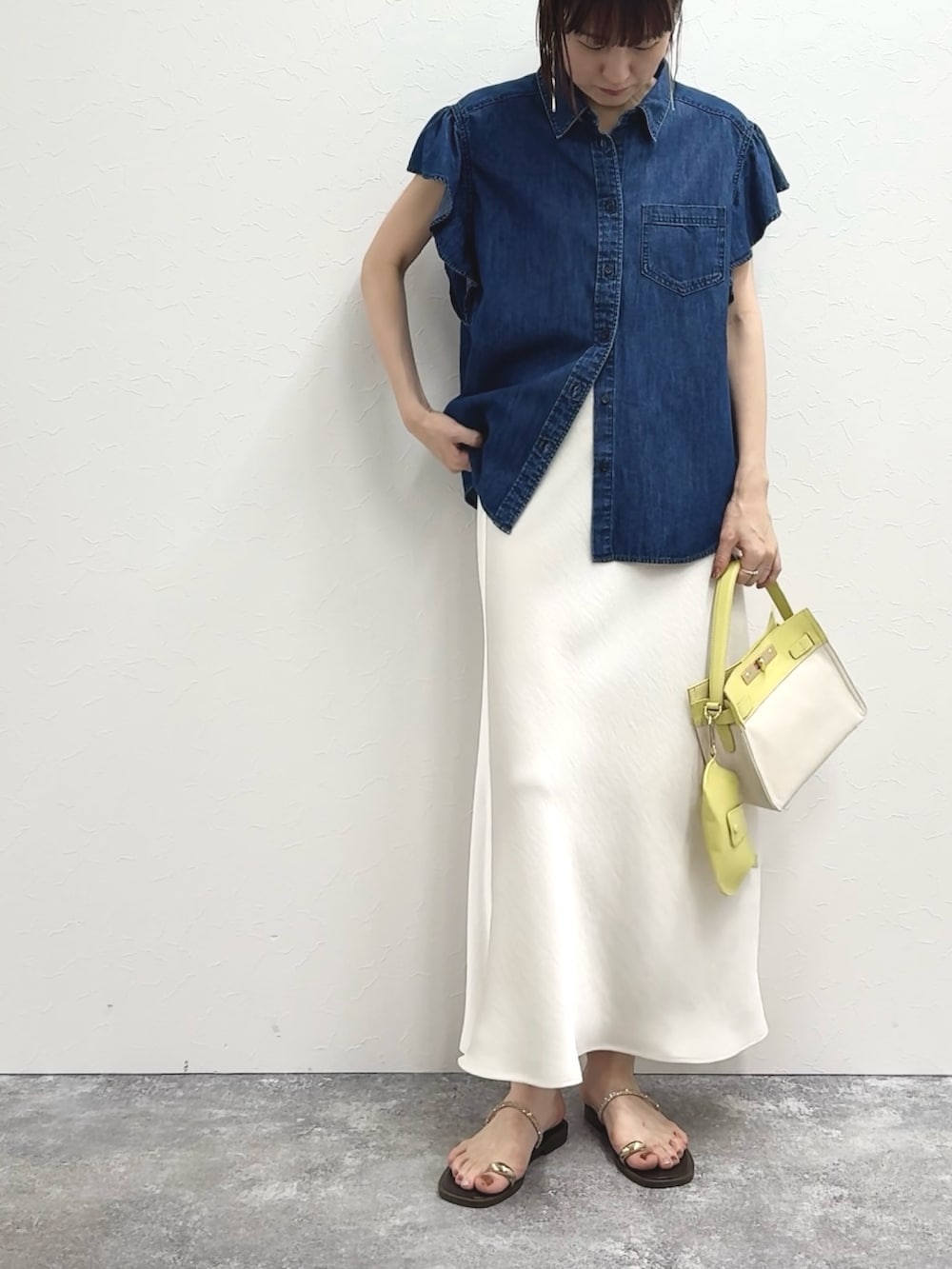 ブルー系のシャツ/ブラウス、イエロー系のショルダーバッグ、ホワイト系のスカートを着用したレディースの冬コーディネートの2枚目の写真