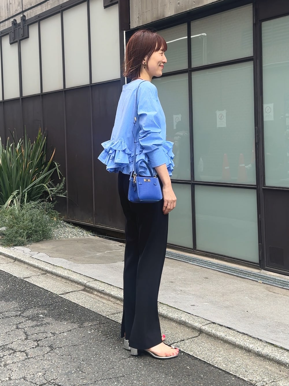 ブルー系のシャツ/ブラウス、ブラック系のその他パンツ、ベージュ系のショルダーバッグを着用したレディースの春コーディネートの7枚目の写真