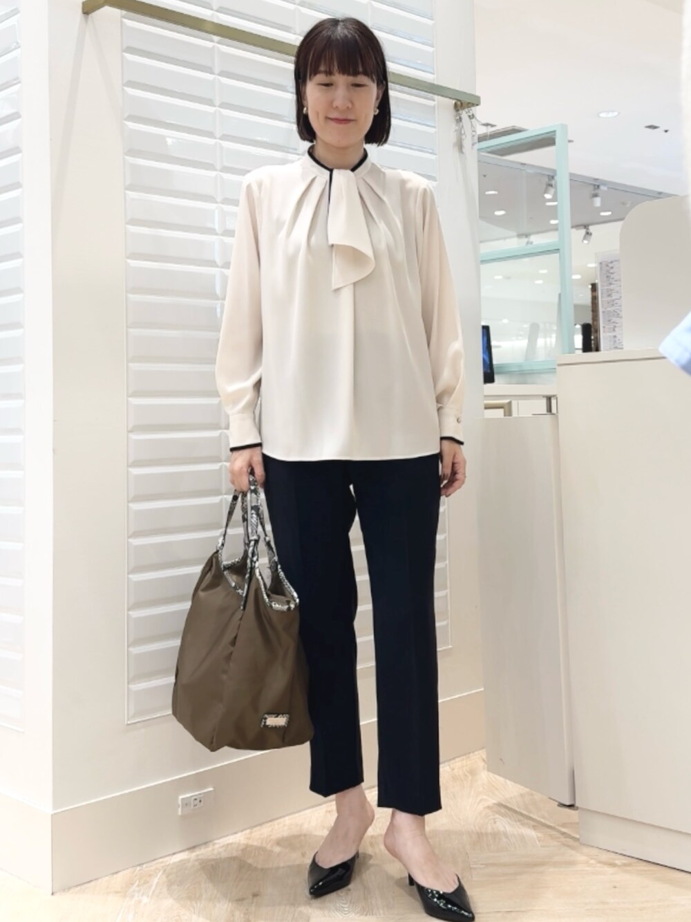 ブルー系のその他パンツ、ブラウン系のトートバッグ、ホワイト系のシャツ/ブラウスを着用したレディースの秋コーディネートの7枚目の写真