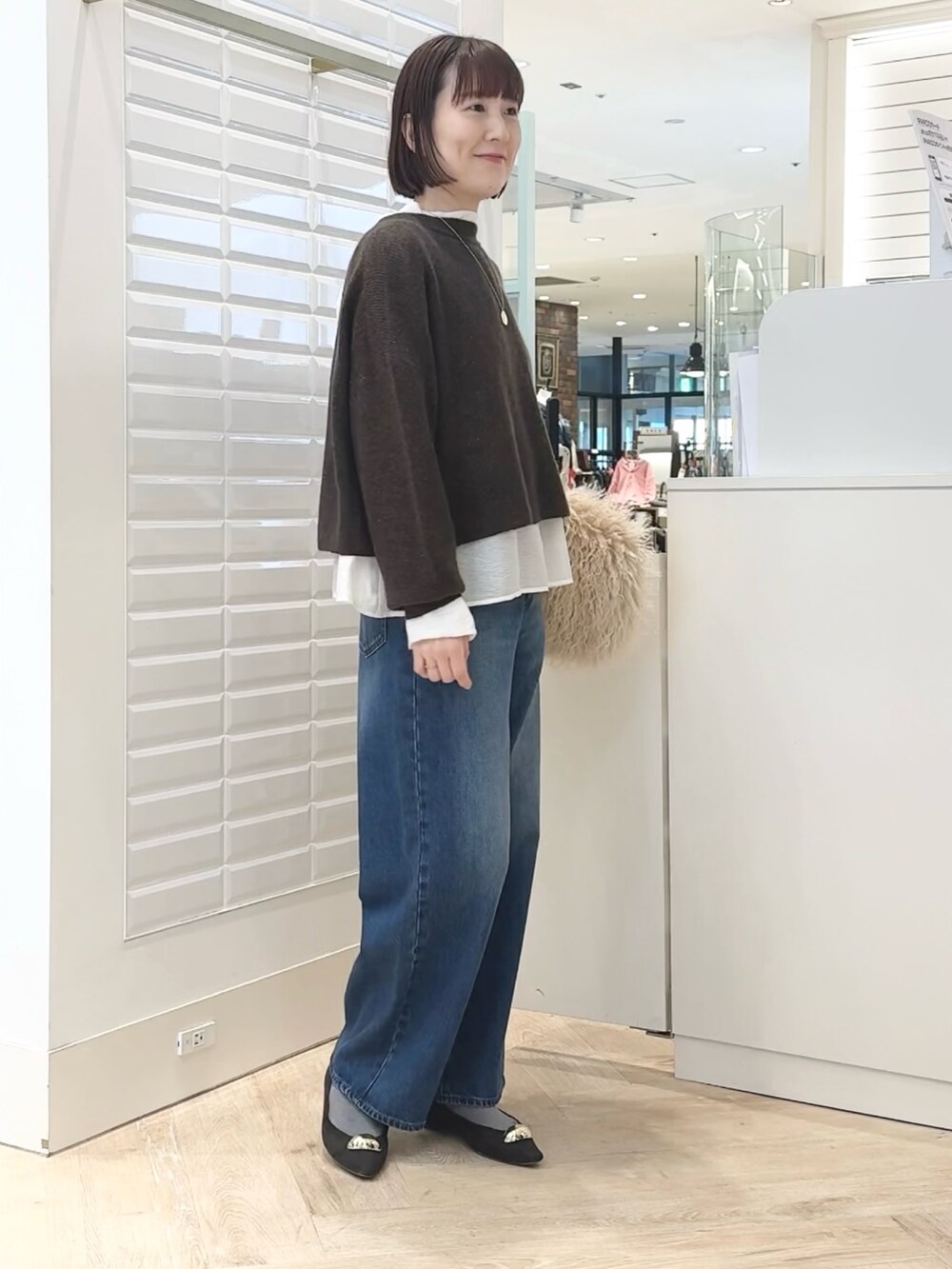 ベージュ系のショルダーバッグ、ホワイト系のシャツ/ブラウス、ブラウン系のニット/セーターを着用したレディースの冬コーディネートの7枚目の写真