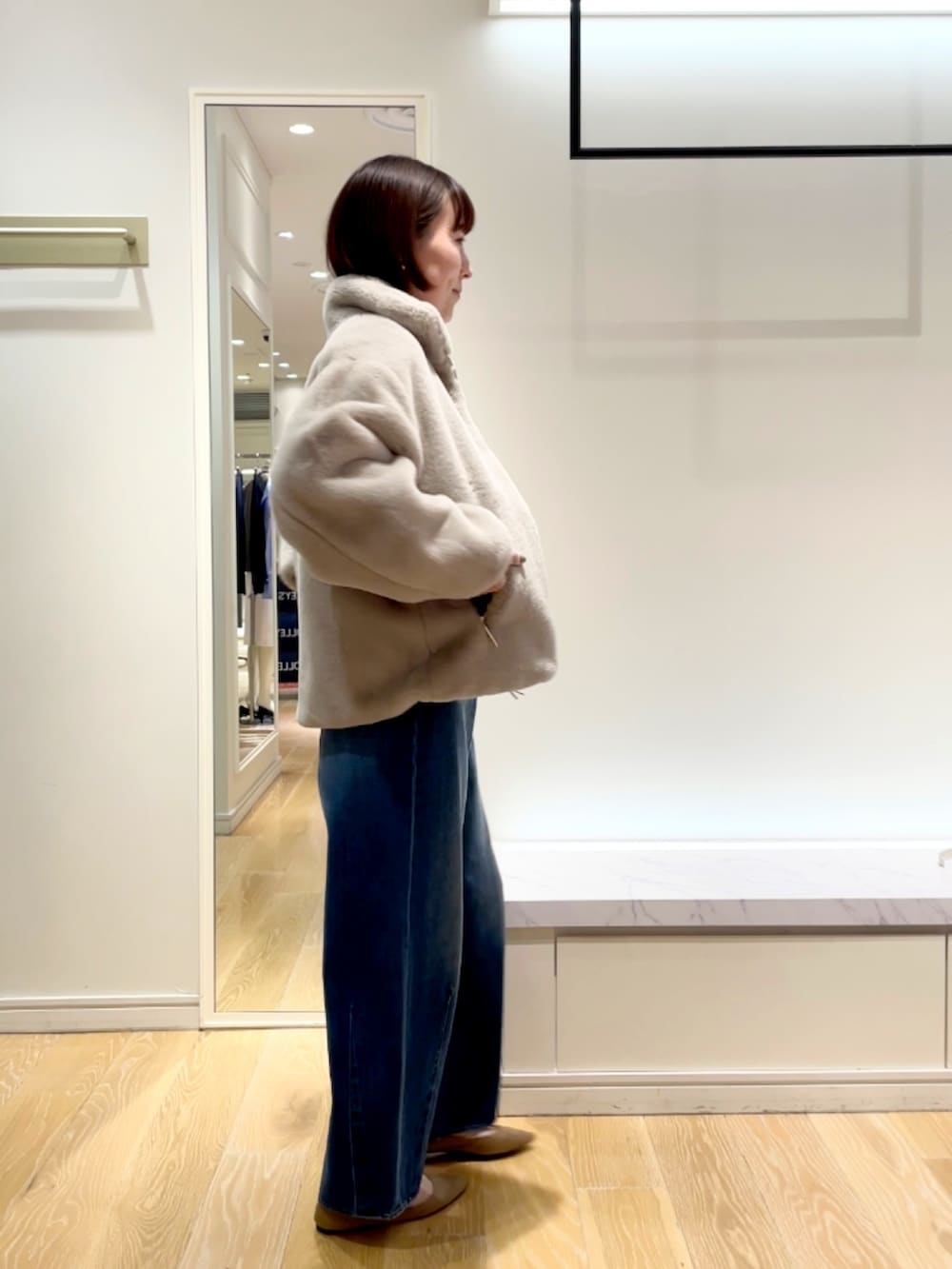 ブルー系のデニムパンツ、グレー系のブルゾン、ブラック系のニット/セーターを着用したレディースの秋コーディネートの8枚目の写真