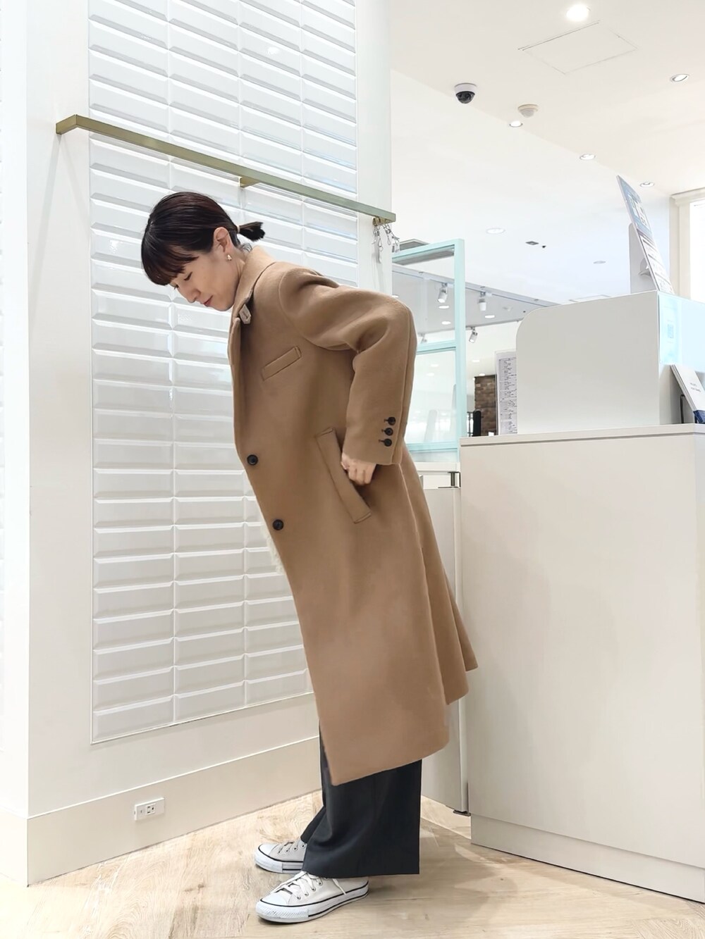 グレー系のベスト、ブルー系のシャツ/ブラウス、ホワイト系のショルダーバッグを着用したレディースの秋コーディネートの6枚目の写真