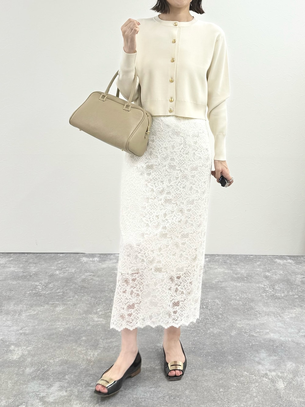 ホワイト系のカーディガン/ボレロ、ベージュ系のショルダーバッグ、ホワイト系のスカートを着用したレディースの秋コーディネートの7枚目の写真