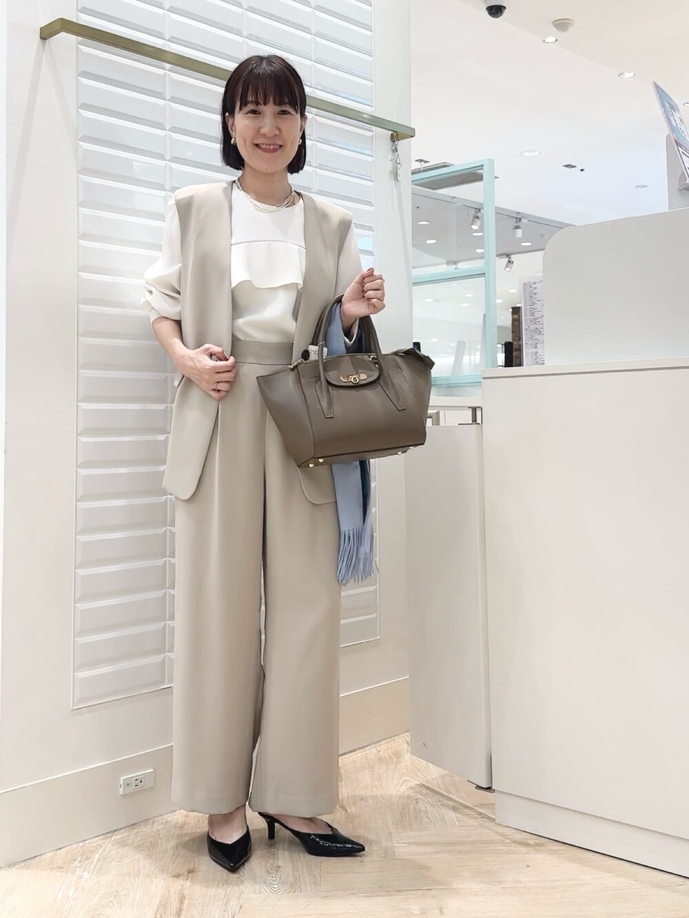 ブラウン系のショルダーバッグ、ベージュ系のその他パンツ、ベージュ系のベストを着用したレディースの秋コーディネートの7枚目の写真