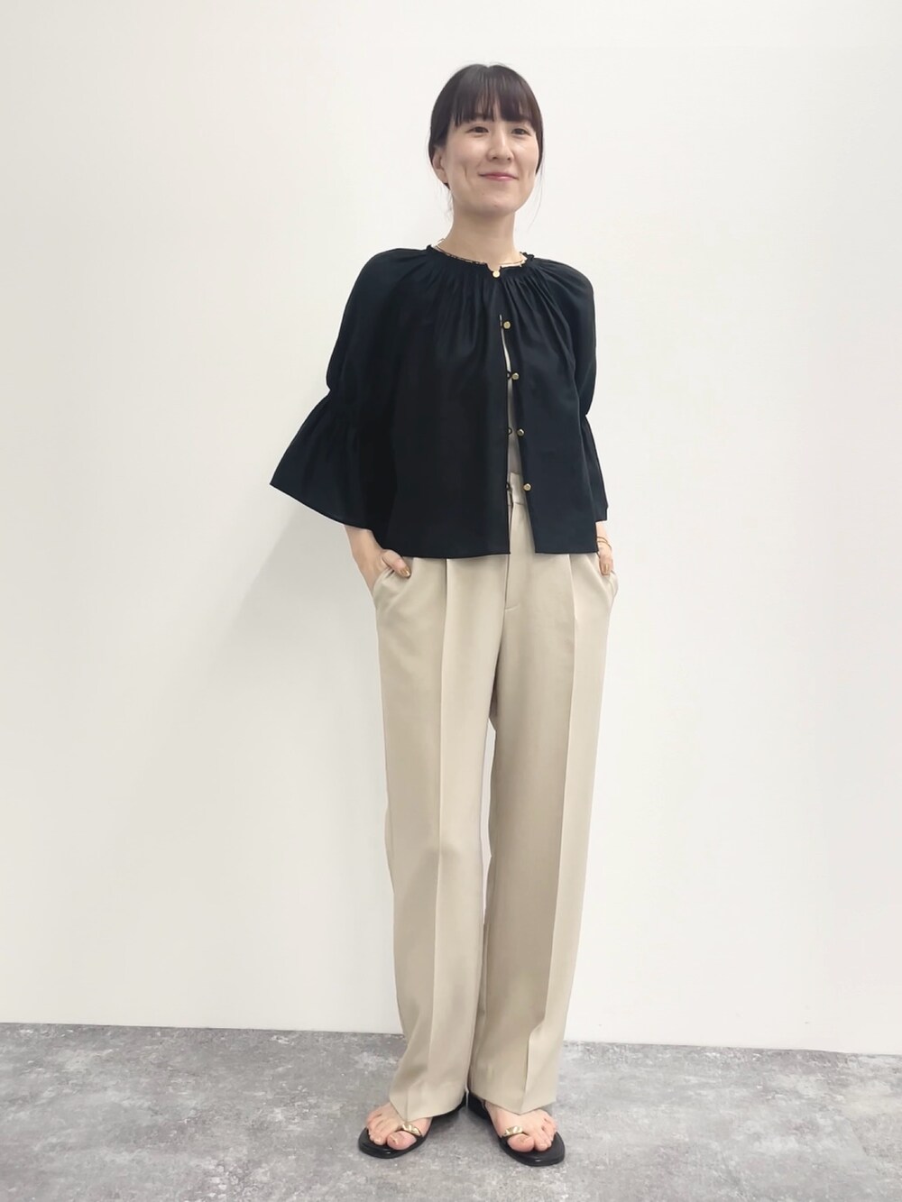 ベージュ系のその他パンツ、ベージュ系のニット/セーター、ブラック系のシャツ/ブラウスを着用したレディースの春コーディネートの4枚目の写真