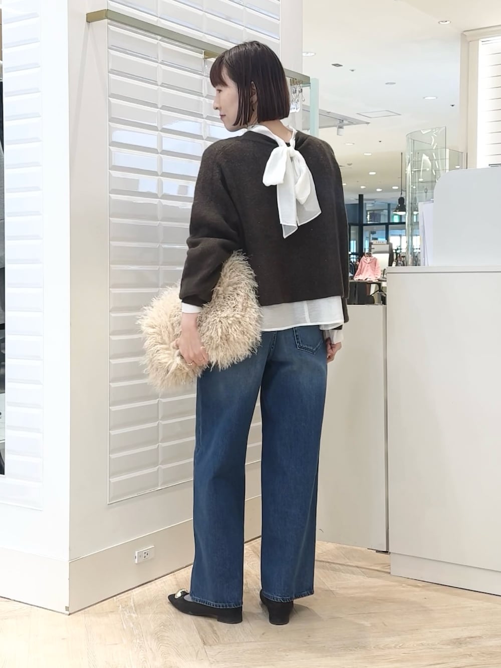 ベージュ系のショルダーバッグ、ホワイト系のシャツ/ブラウス、ブラウン系のニット/セーターを着用したレディースの冬コーディネートの3枚目の写真