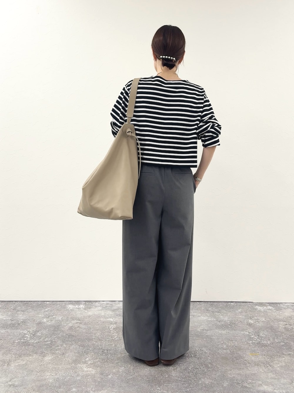 ブラック系のTシャツ/カットソー、ベージュ系のショルダーバッグ、グレー系のその他パンツを着用したレディースの秋コーディネートの4枚目の写真