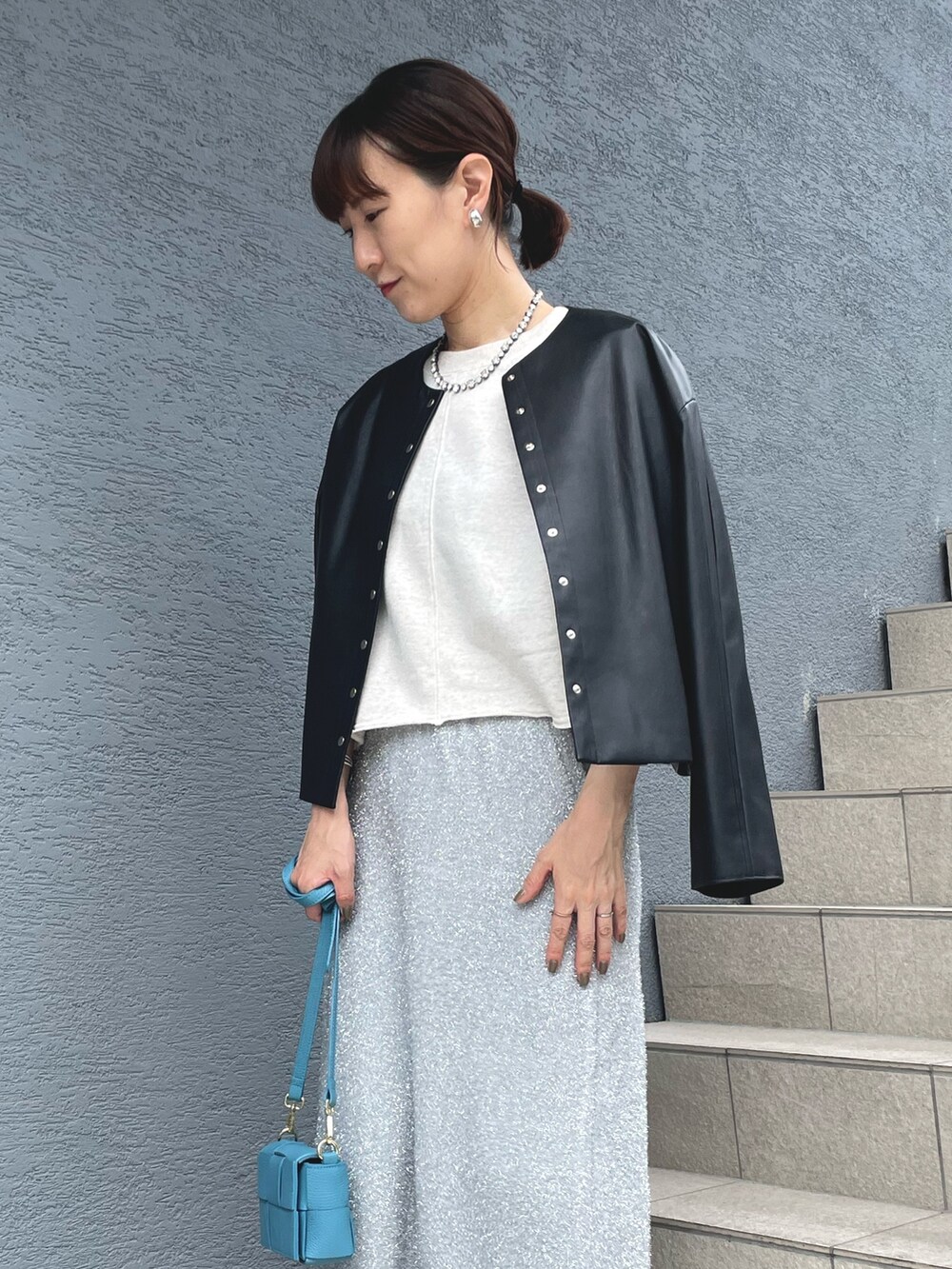 ブルー系のショルダーバッグ、ブラック系のサンダル、ブラック系のブルゾンを着用したレディースの秋コーディネートの7枚目の写真