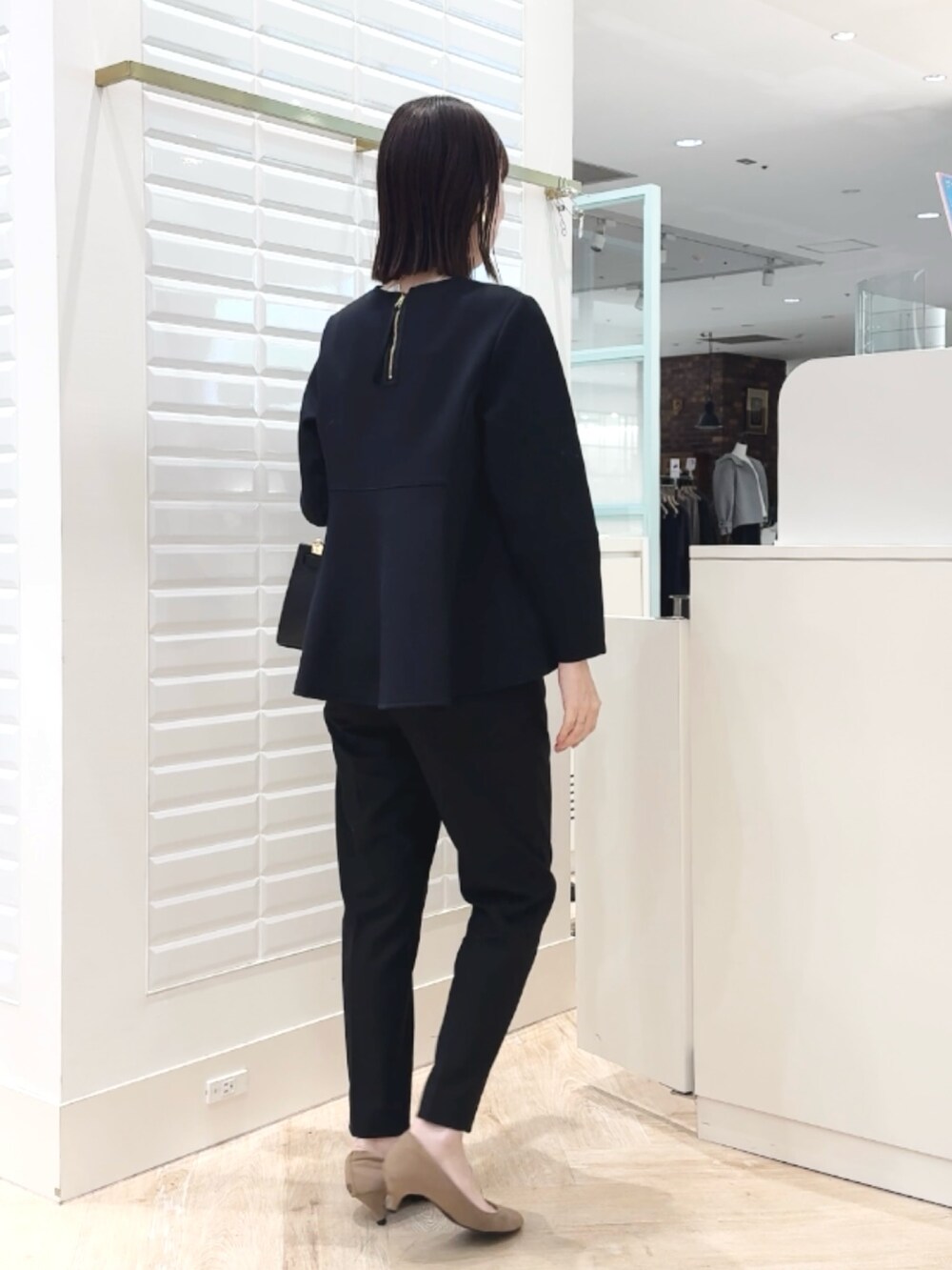 ブラック系のショルダーバッグ、ブラック系のその他パンツ、ブラック系のTシャツ/カットソーを着用したレディースの冬コーディネートの9枚目の写真