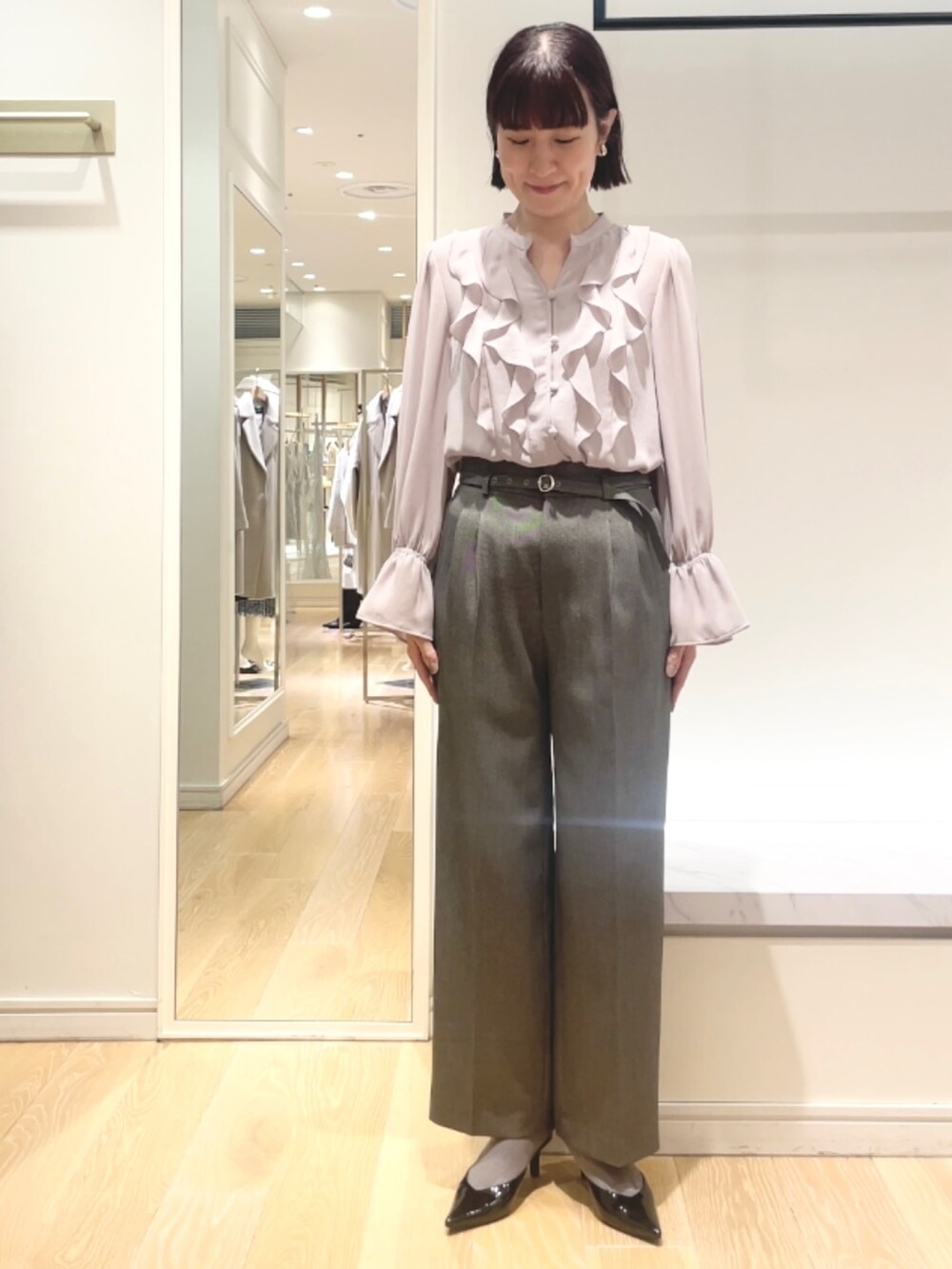 グレー系のその他パンツ、ピンク系のシャツ/ブラウス、ゴールド系のイヤリングを着用したレディースの冬コーディネートの3枚目の写真