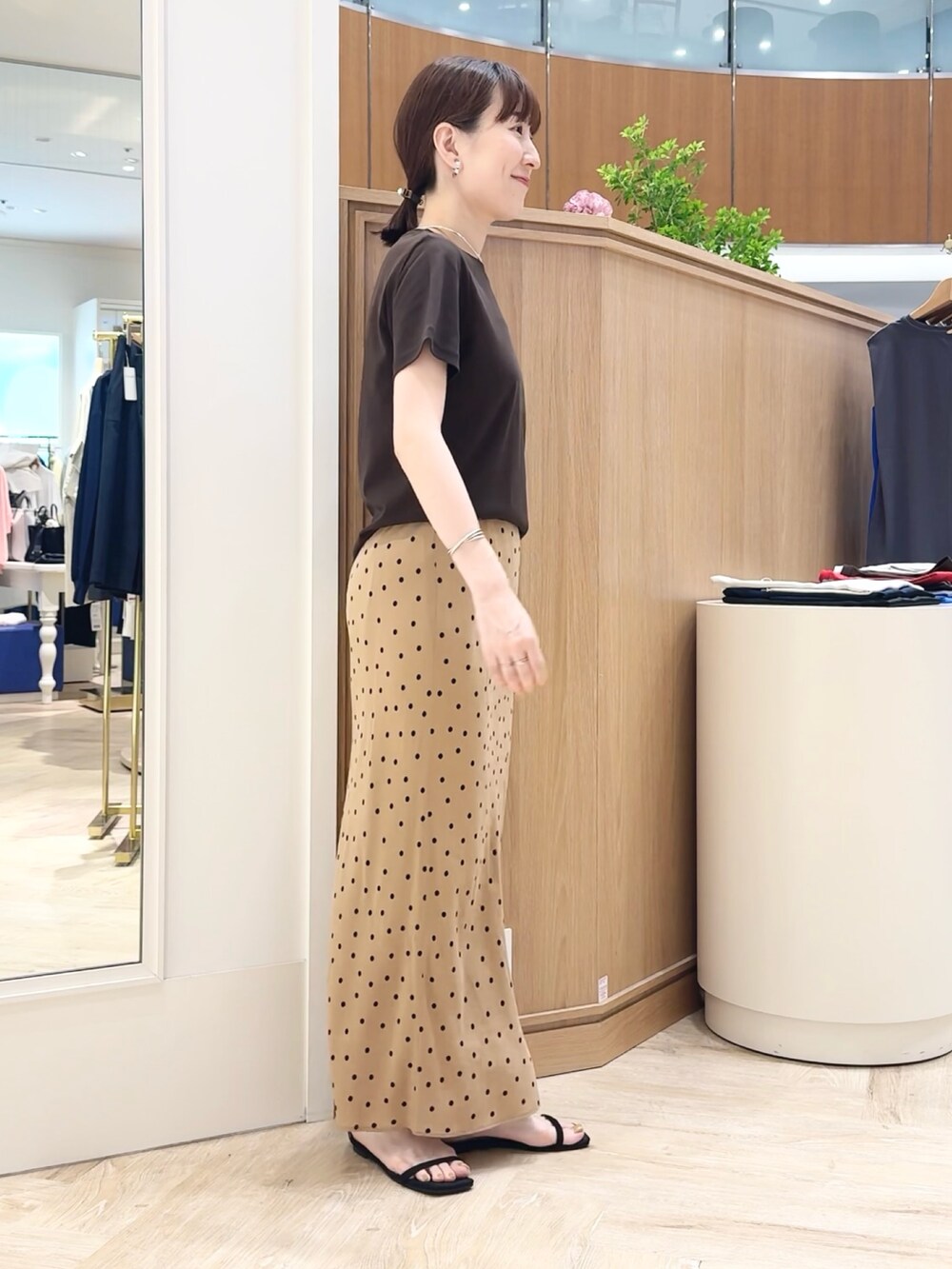 ブラウン系のスカート、ブラウン系のTシャツ/カットソー、シルバー系のチョーカーを着用したレディースの夏コーディネートの8枚目の写真
